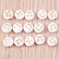 Vista piana di perline in acrilico bianco con varie espressioni su sfondo in legno chiaro - Confezione da 100 / Emoji Oro Bianco (1337)