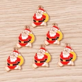 Detalle de seis colgantes de Papá Noel en esmalte con aros dorados sobre fondo de madera - Paquete de 10 / Muñeco de Nieve Amarillo