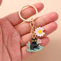 Detailed close-up of a golden alloy black cat keychain with pink daisy and ladybug charm - Cyan Wave Cat Style (1453hua)