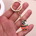 Détail du porte-clés citrouille d'Halloween avec anneau doré et chapeau de sorcier noir - Tête de Citrouille Orange