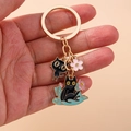 Detail of a gold enamel keychain featuring black cat pendants and cherry blossom charm - Standing Black Cat Style (1453hehua)