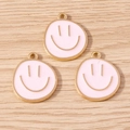 Close-up of pink enamel smiley face charms with gold trim for DIY jewelry making - 10 Pieces Pack / Pink