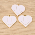 Detailed close-up of golden heart smiley face enamel charms on a light wood background - 10 Pieces Pack / White