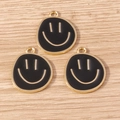 Three black enamel smiley face charms with gold metal edges on a light wooden background - 10 Pieces Pack / Black