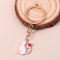 Dettaglio portachiavi gatto in smalto rosa con cuore rosso su base in legno - Rosa