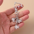 Schattige dolfijnvormige metalen sleutelhanger met drie roze gestreepte vis-hangers - Koi