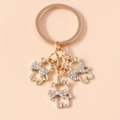 Dettaglio di portachiavi a forma di orsetto dorato con fiocchi in strass colorati - Oro