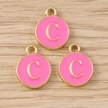 Detailansicht von drei rosa Emaille-Anhängern mit goldenem Buchstabe C für DIY-Schmuck - Buchstabe C / 10er Pack