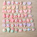 Makro-Detail von Pastell-Harz-Cabochons mit Tieren und Früchten für DIY-Schmuckherstellung - Dessert Mischung