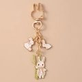 Détail d'un porte-clés lapin en métal doré avec breloques en émail et fermoir forme lapin - Lapin Fourchette