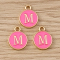 Detail of pink enamel letter M charms with gold plating and hanging loop on wood - Letter M / 10 Pieces Pack