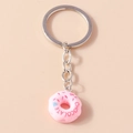 Dettaglio del portachiavi a ciambella rosa con scritta chocolate su fondo pastello - Ciambella Rosa