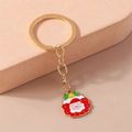 Dettaglio portachiavi Babbo Natale dorato con smalto colorato e campanellino decorativo - Stile Babbo Natale / Rosso
