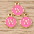 Close-up of three gold circular charms with pink enamel and a gold letter W pendant - Letter W / 10 Pieces Pack