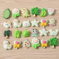 Macro detail of 24 assorted resin cartoon charms with silver rings for DIY jewelry - Green