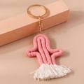 Gros plan d'un porte-clés cactus rose tricoté main avec pompon blanc et anneau doré - Rose