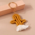 Vue macro d'un porte-clés cactus en macramé fait main avec pompon en coton et anneau doré - Jaune