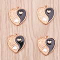 Detailed macro view of heart-shaped Yin Yang pendants with enamel and gold texture - Black