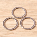 Three silver-plated alloy key rings on a wooden background for DIY jewelry making - 5 Pieces / Silver