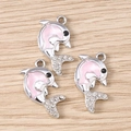 Tre ciondoli a delfino argento con smalto rosa e strass bianchi su fondo legno - Rosa Argento
