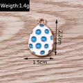 Detailed view of enamel egg pendant with blue dots, size 2.2x1.5cm on wood background - 10 Pieces Pack / White Background Blue Polka Dots (YD1082)
