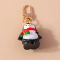 Llavero de pingüino navideño en resina con bufanda festiva y gancho de metal dorado - Pingüino