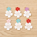 Detailed macro view of six enamel cherry blossom flower charms with colorful alloy petals - Multicolor
