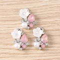 Makro-Detail von DIY-Blumenanhängern mit rosa Edelsteinen und weißen Kunstperlen - 10er Pack / Silberrosa