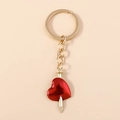 Detailed view of creative red heart pendant with a gold nail accent on a keychain - Gold With Red Heart