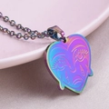 Detailed macro shot of a rainbow-colored heart pendant featuring a crying face engraving - Necklace / Rainbow
