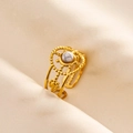 Dettaglio macro di anello dorato con marmo bianco e trama con perline traforata - Oro Bianco