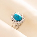 Makroaufnahme eines Vintage-Rings aus 304 Edelstahl mit ovalem Türkis und Sonnenblumenmotiv - Silberbasis Dunkelblauer Stein