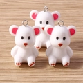 Close-up of three cute white resin bear pendants with pink ears and silver metal loops - White