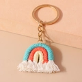 Detail of handmade macrame rainbow keychain with colorful cotton rope and white fringe - Blue