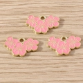 Detailed close-up of pink cherry blossom enamel pendants with gold alloy edges for jewelry DIY - 10 Pieces Pack / Pink (YD2161)