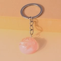 Dettaglio macro di un ciondolo a spirale in resina rosa traslucida con anello portachiavi - Rosa