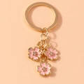 Detail of pink enamel cherry blossom keychain with gold alloy finish and tiny rhinestones - Pink