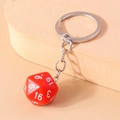 Macro shot of a red 20-sided D20 dice keychain with white numbers and silver metal ring - Red