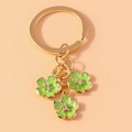 Llavero creativo con flores verdes de cinco pétalos, acabado esmaltado y centro de cristal - Verde