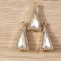 Detailed view of three gold geometric triangle crystal pendants on a light wood surface - 10 Pieces Pack / Gold White
