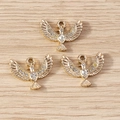 Three gold eagle bird charms with crystal rhinestones on a light wood background - 10 Pieces Pack / Gold