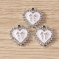 Detail van roze hartvormige bedeltjes met zilveren strik en strass op hout - 10 Stuks Verpakking / Zilver Roze