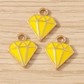 Macro-opname van drie gele emaille diamantvormige hangers op houten ondergrond - 10 Stuks Verpakking / Geel