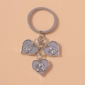 Portachiavi in argento con tre ciondoli a cuore con angelo su sfondo rosa chiaro - Cuore in Rilievo (Argento)