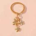 Detailed close-up of golden metal star keychain with three sparkling crystal pendants - Gold