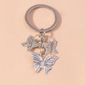 Detail of silver alloy butterfly keychains with solid embossed and hollow mesh charms - Silver