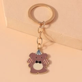 Detailed close-up of cartoon bear enamel keychain with gold ring and party hat accessory - Birthday Bear