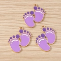 Detailed macro view of purple enamel baby footprint pendants with golden zinc alloy edges - 10 Pieces Pack / Purple