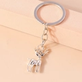 Portachiavi alce in metallo argento lucido su un espositore rosa dal design minimal - Forma di Alce (YZ438)
