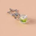 Close-up of creative coffee cup keychain with star-shaped clasp and glowing green liquid - Green